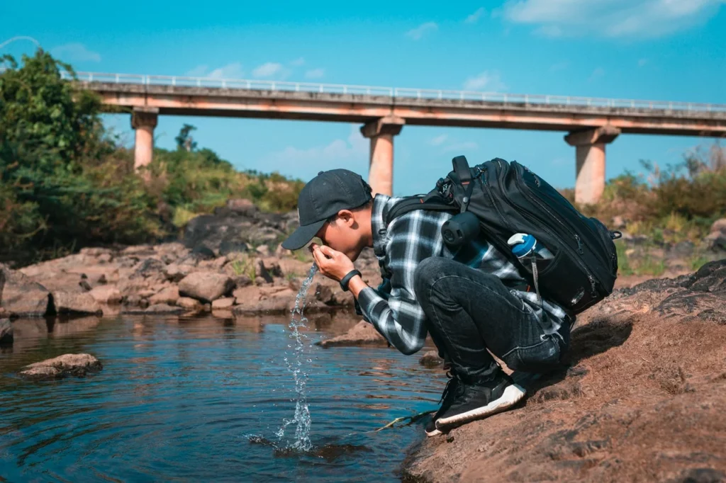 Boy drinking impure lake water